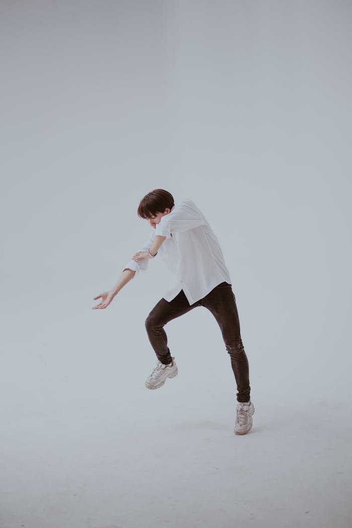 Artistic photo of a dancer captured in mid-motion with a clean background, showcasing dynamic expression and style.